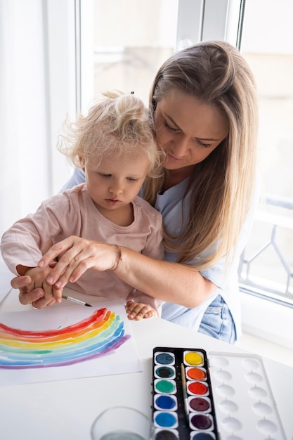 Mamá pintando con niño en casa