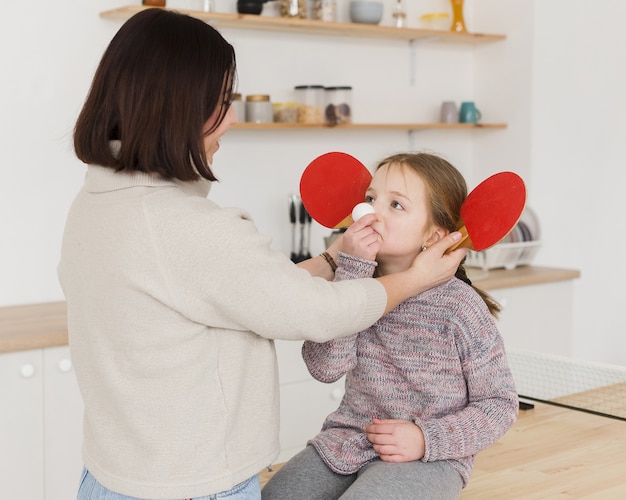 Foto gratuita mamá siendo juguetona con adorable hija