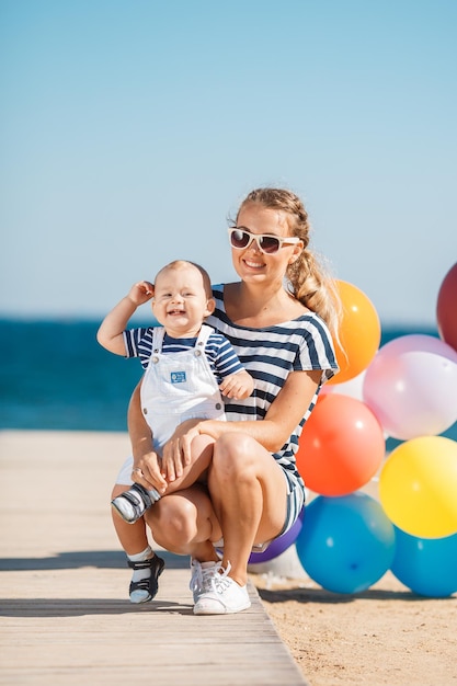 mamá sonriente con un lindo bebé al aire libre