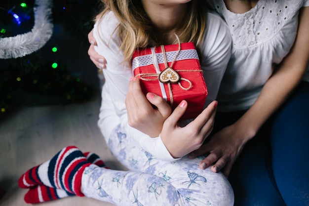 Mamá y su niña linda hija intercambiando regalos.