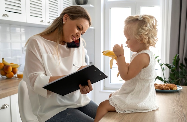 Mamá trabajando en casa con el niño durante la cuarentena