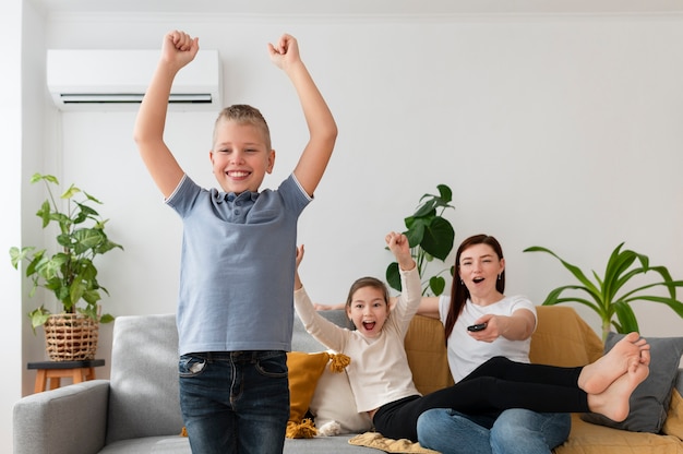 Foto gratuita mamá viendo la televisión con sus hijos.