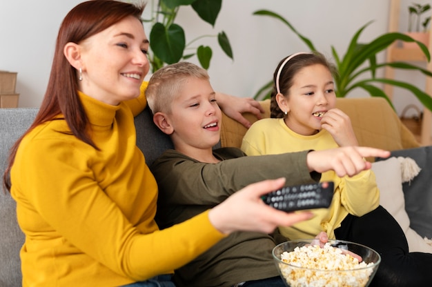 Foto gratuita mamá viendo la televisión con sus hijos.