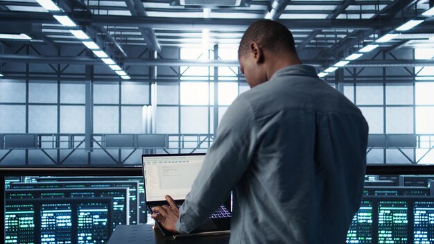 Man coding on data center testing failover scenarios using notebook