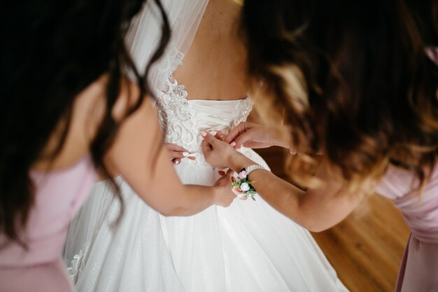 Mañana de la novia cuando ella lleva un hermoso vestido.