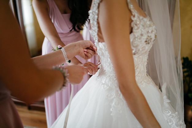 Mañana de la novia cuando ella lleva un hermoso vestido.