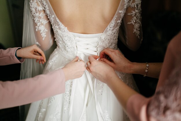 Mañana de la novia cuando ella lleva un hermoso vestido.