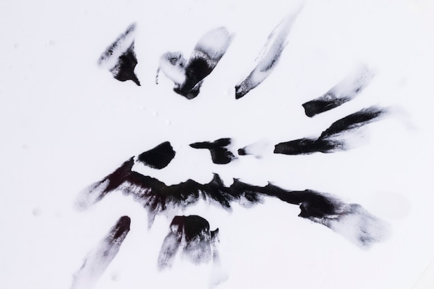 Manchas de acuarela negro aislado en superficie blanca lisa