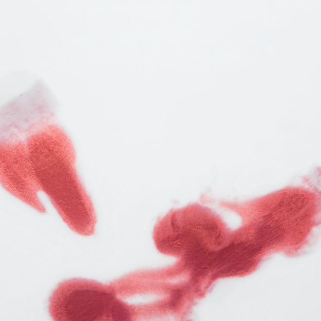 Manchas de acuarela roja aisladas sobre superficie blanca