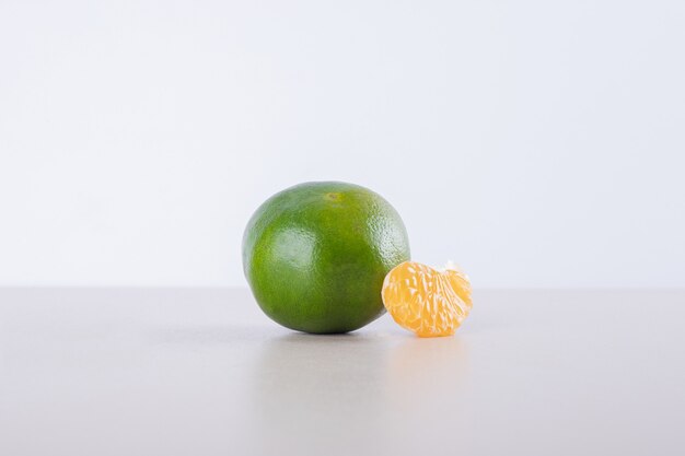 Mandarina verde con mandarina minúscula.