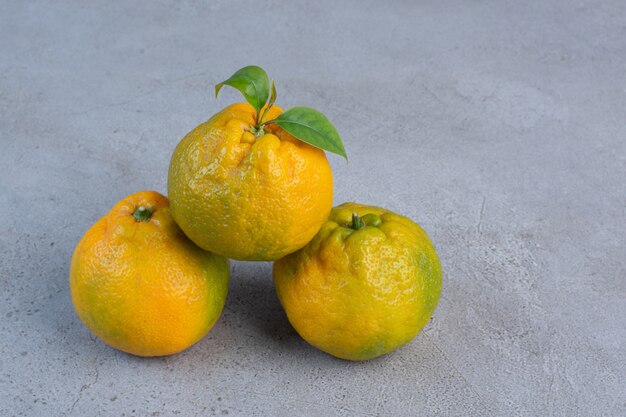 Mandarinas jugosas agrupadas que se muestran en el fondo de mármol.