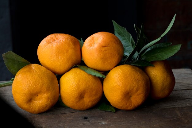 Mandarinas naranjas con hojas verdes.