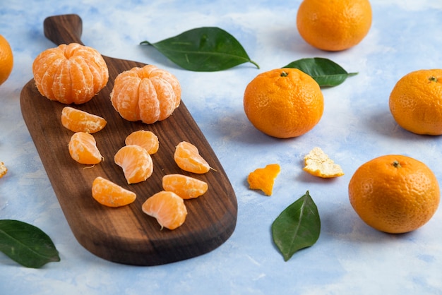 Mandarinas orgánicas peladas al lado de mandarinas enteras