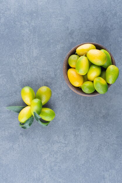 Mandarinas pequeñas frescas en un tazón de madera.