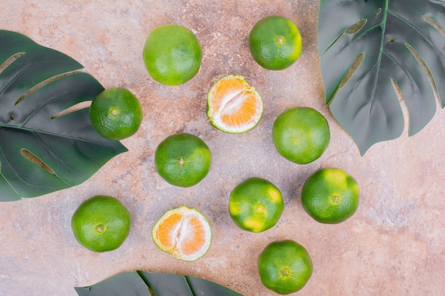 Mandarinas sobre una superficie con hojas verdes