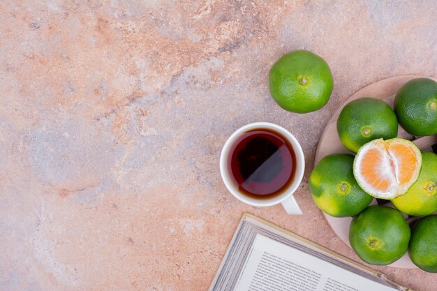 Mandarinas verdes aisladas en mármol.