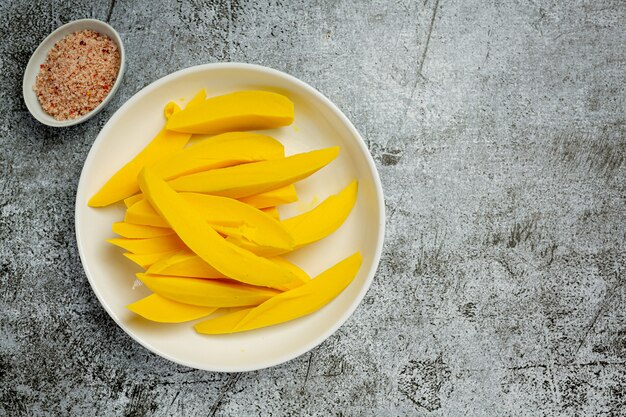 Mango en escabeche sobre superficie de madera oscura.