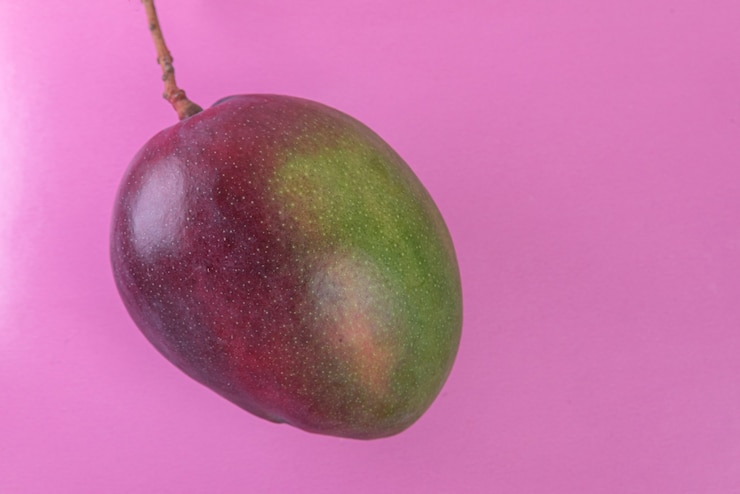 Foto gratuito mango en la superficie rosa