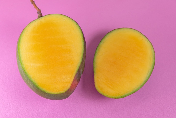 Foto gratuito mango en la superficie rosa