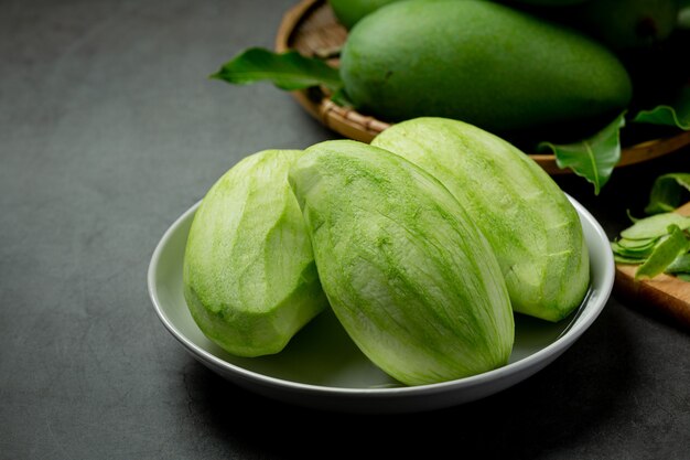 Mango verde fresco sobre superficie oscura