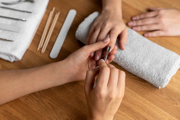 Foto gratuita manicurista de cerca con herramienta de uñas