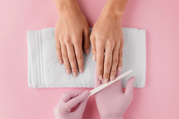 Manicurista de primer plano limar las uñas