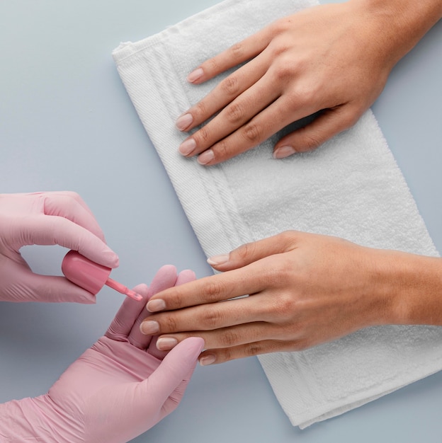 Manicurista de primer plano pintando uñas