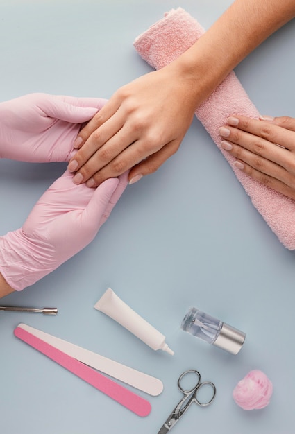 Manicurista de primer plano sosteniendo la mano del cliente