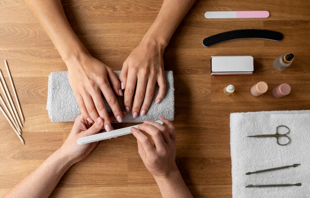 Manicurista sosteniendo la herramienta de uñas de cerca