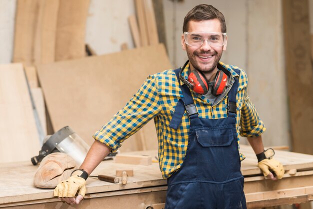 Manitas sonrientes que llevan las gafas de seguridad que miran la cámara