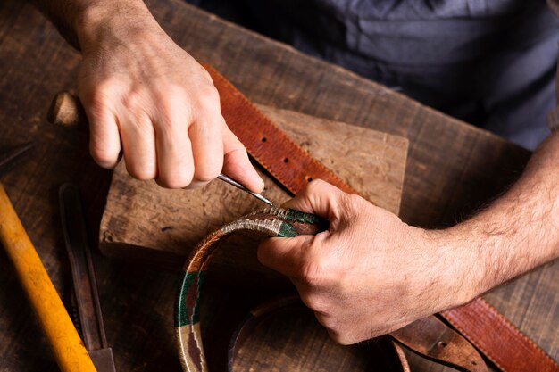 Manitas trabajando en un cinturón de cuero