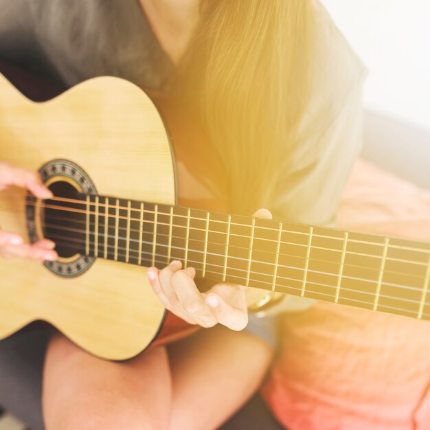 La mano del adolescente tocando la guitarra