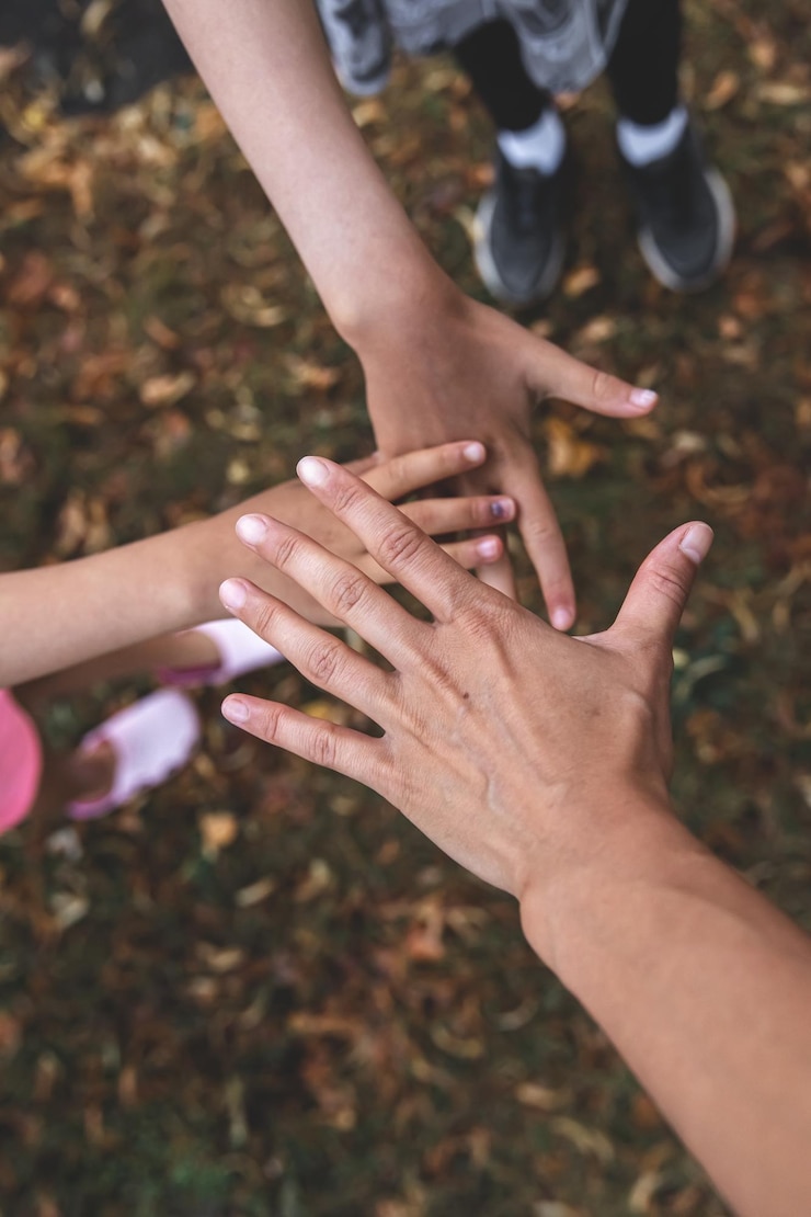 Foto gratuito la mano de un adulto y dos niños juntos un símbolo de amistad