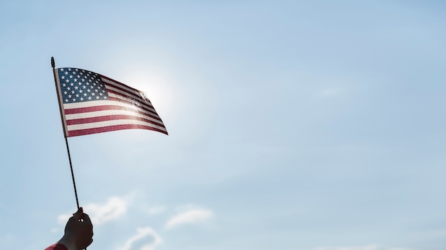 Mano agitando la bandera de Estados Unidos