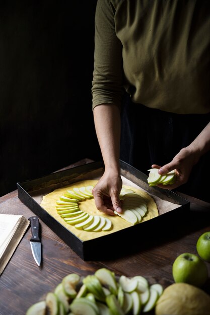 Mano de alto ángulo arreglando rodajas de manzana