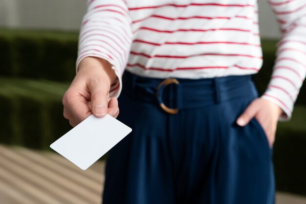 Mano de alto ángulo que sostiene la tarjeta de visita en blanco