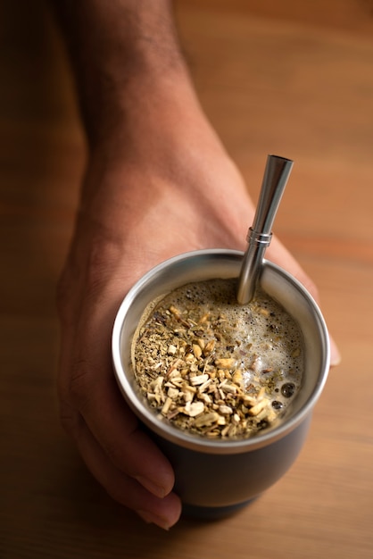 Foto gratuita mano de alto ángulo sosteniendo una taza de té