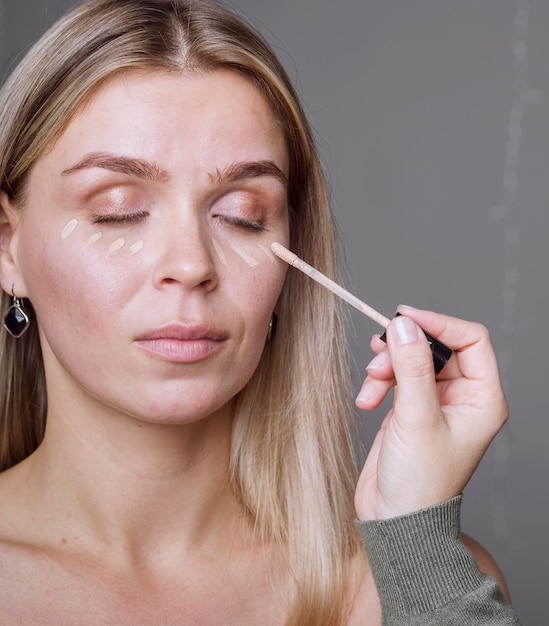 Mano aplicando maquillaje en modelo