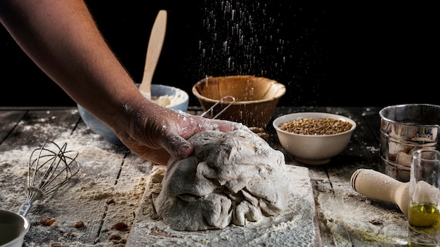 Foto gratuita mano de baker amasando la masa en la mesa de la hornada