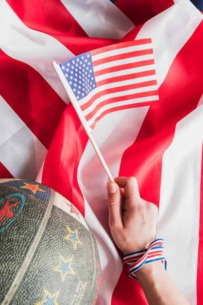 Mano con bandera de Estados Unidos y baloncesto.