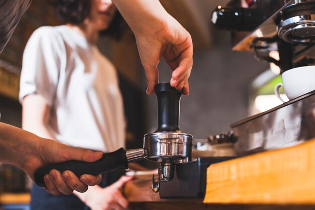 Mano de barista preparando capuchino en cafetería