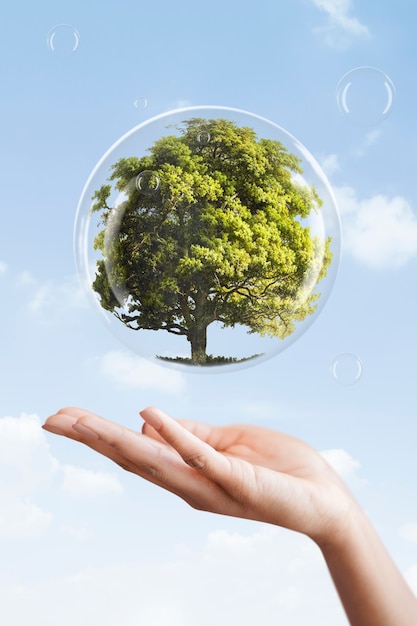 Mano de la campaña del día de la tierra mostrando el árbol en una mezcla de medios de burbuja