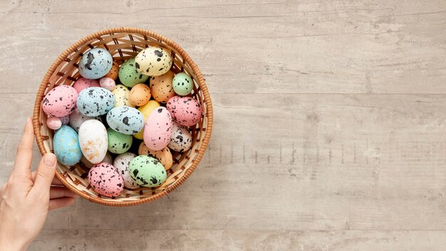 De la mano con la canasta llena de huevos para pascua