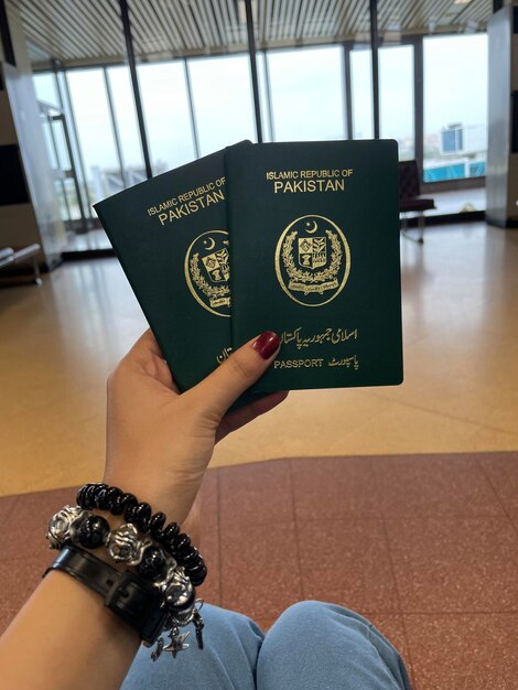 Mano de cerca sosteniendo el pasaporte de Pakistán aislado en fondo blanco