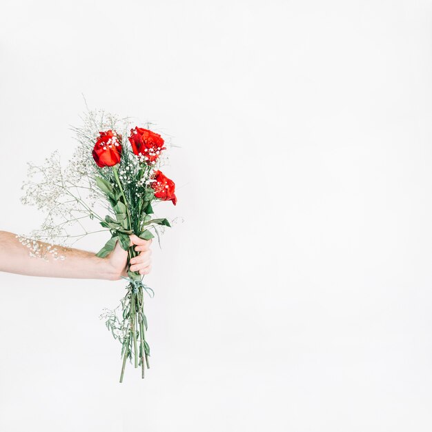 Mano de cosecha mostrando bouquet con rosas