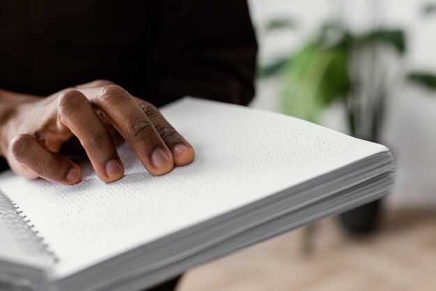 Mano en el cuaderno braille de cerca