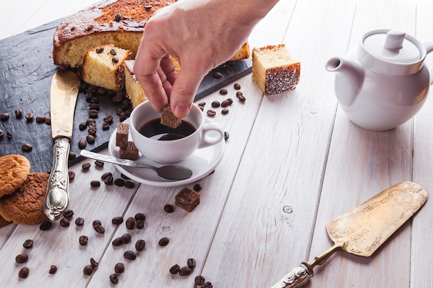 Mano de cultivo agregando azúcar al café