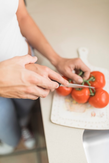 Mano de cultivo ayudando a mujer a cortar verduras