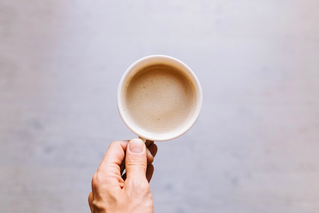 Mano de cultivo sosteniendo la taza de café