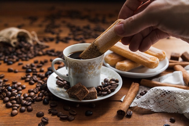 Mano de cultivo sumergir la galleta en el café